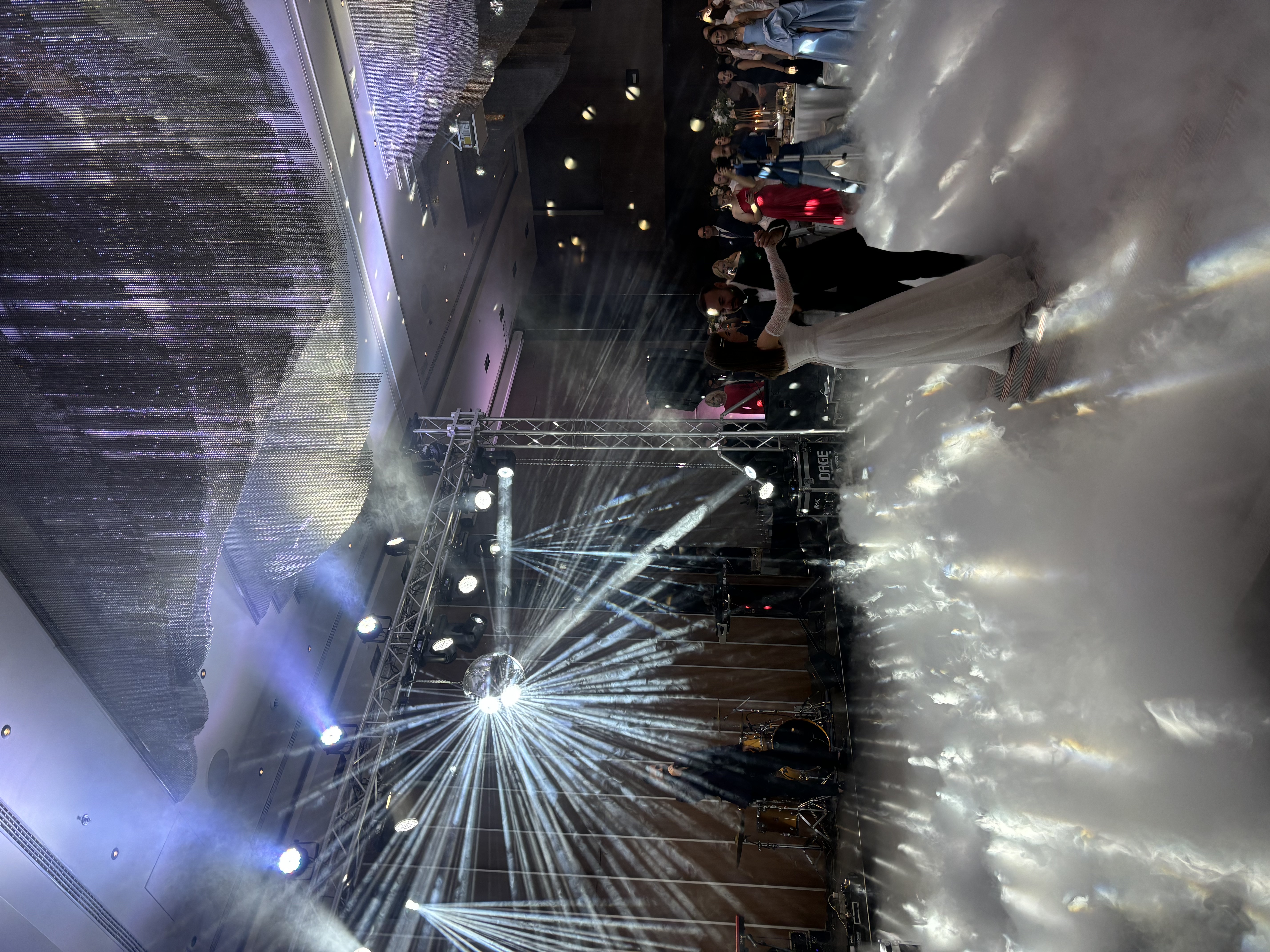 Wedding reception with disco ball, low fog, and truss lighting